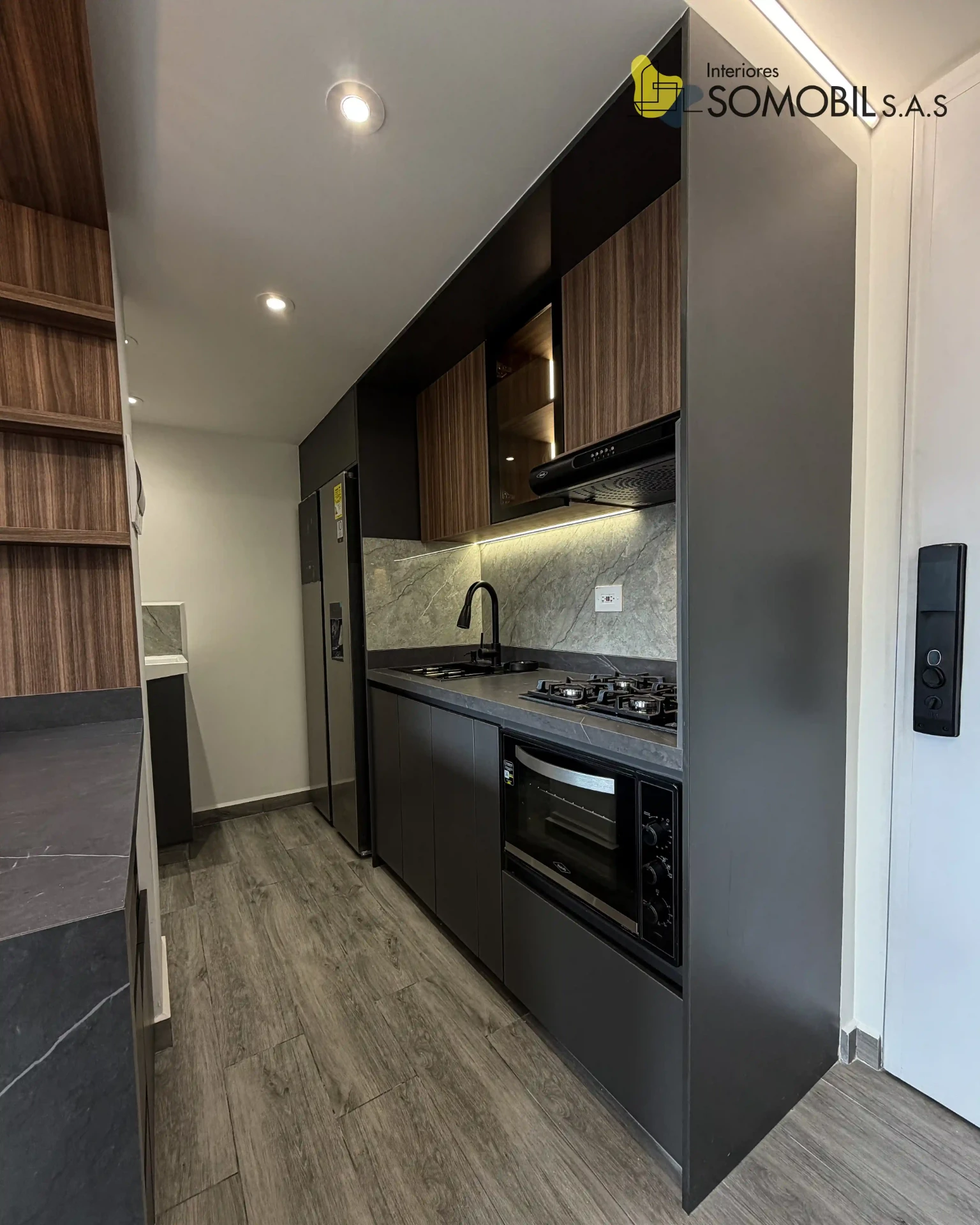 Detalle de cocina negra con iluminación y acabado de madera