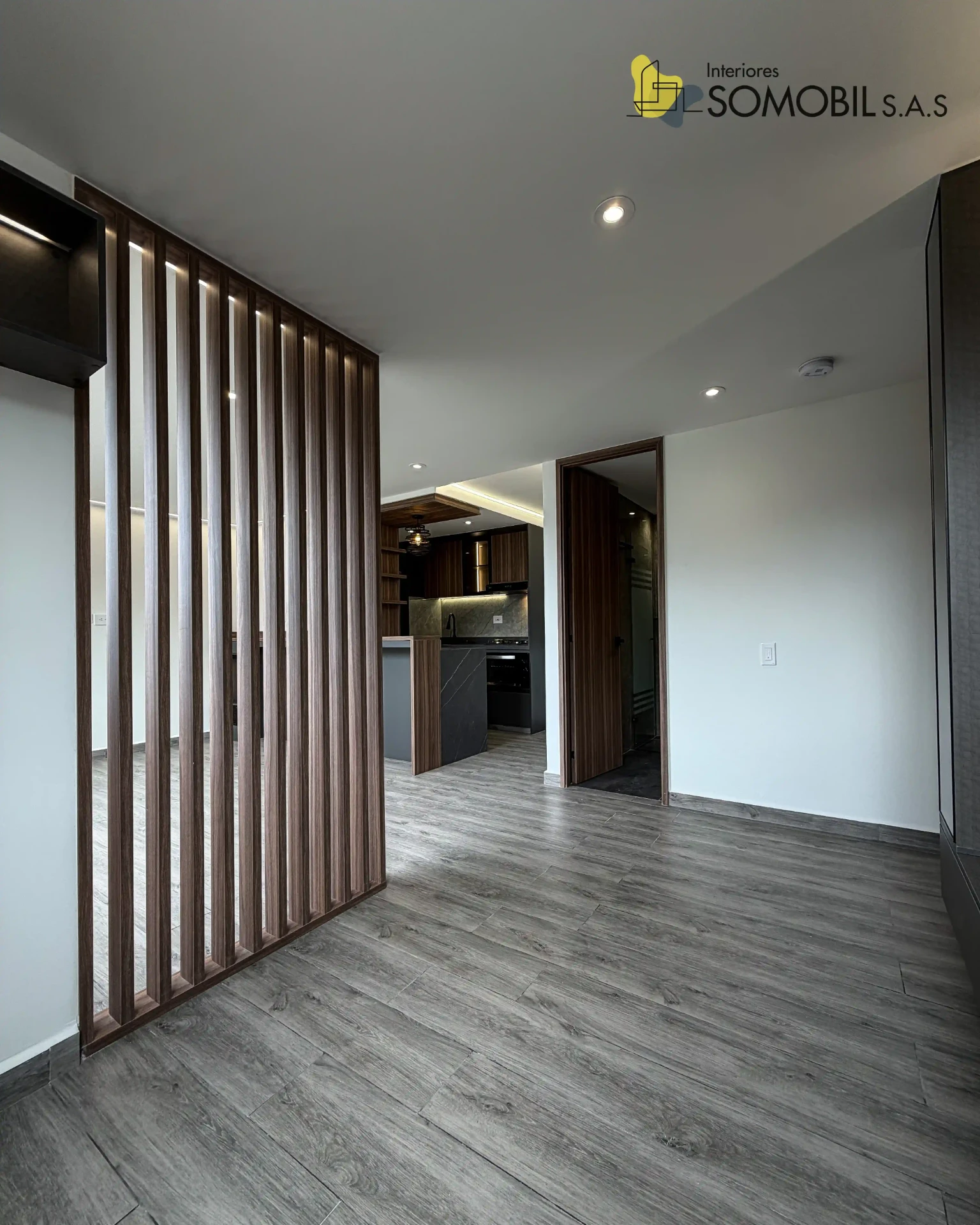 Zona social con división de listones de madera realizada por Interiores Somobil